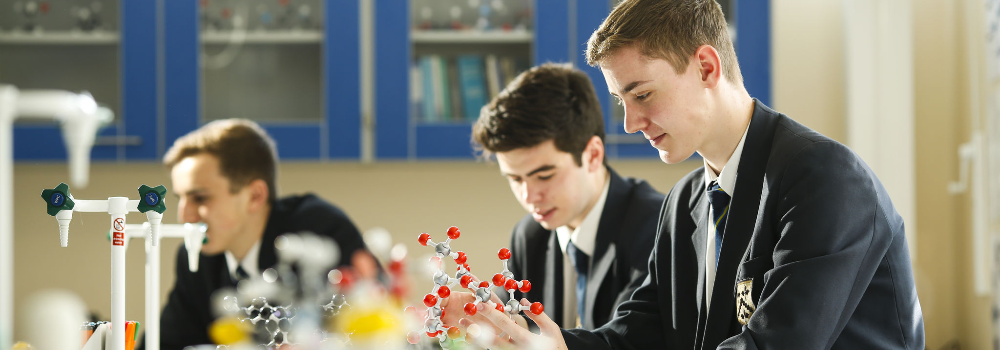 Three boys using equipment to create 3D versions of different atomic structures in a Chemistry lab.