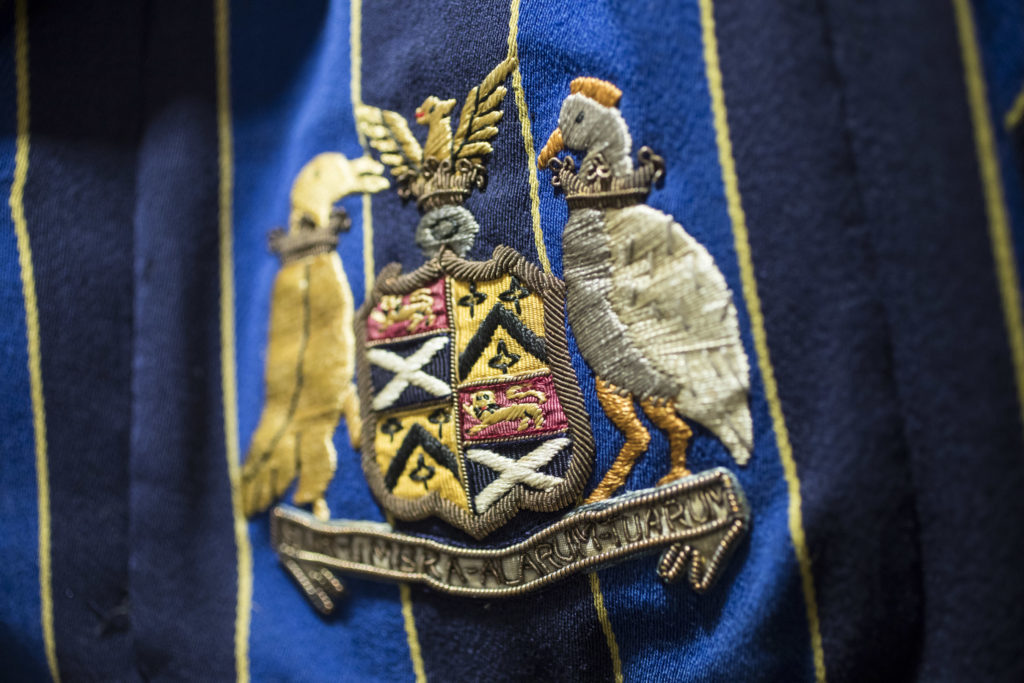 A close up of the school logo on a blazer.